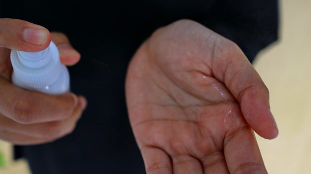 Hand of lady that applying alcohol spray or anti-bacteria spray to prevent the spread of germ photo