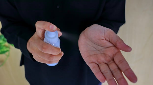 Hand of lady that applying alcohol spray or anti-bacteria spray to prevent the spread of germ photo
