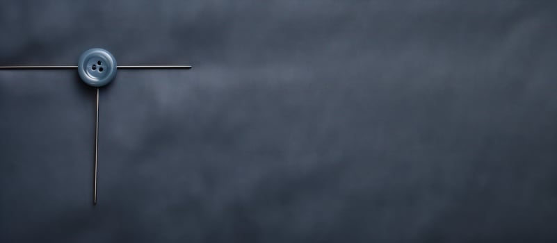 Photo of a blue button on a black background with ample copy space with copy space