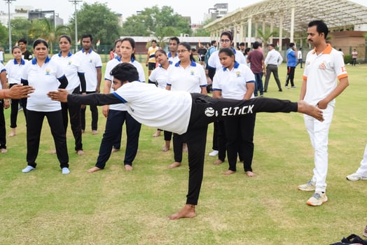 New Delhi, India, June 21, 2023 - Group Yoga exercise session for people at Yamuna Sports Complex in Delhi on International Yoga Day, Big group of adults attending yoga class in cricket stadium photo