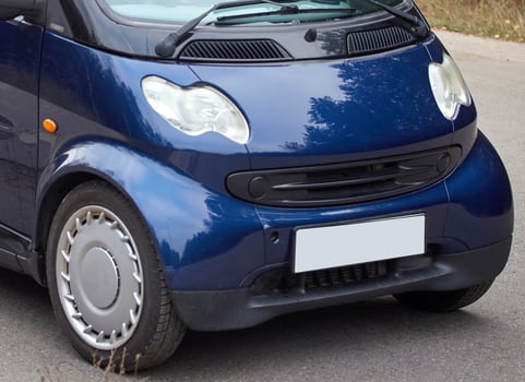Little blue car driving on the road,  modern city car background photo