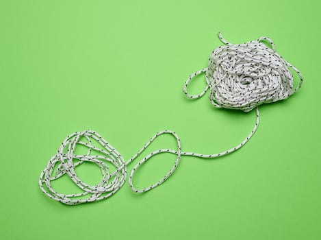 White laundry rope on a green background, top view photo