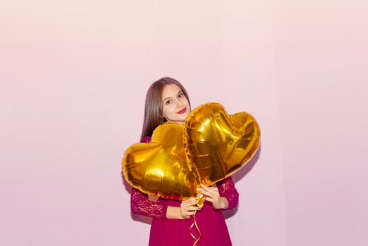woman holds heart shaped golden air balloons. valentines day, birthday, womens day, anniversary, holiday celebration concept photo