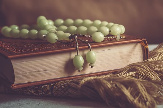 The Holy Quran with rosary and praying carpet. Image of The Holy Quran with rosary. Muslim Rosary Beads And Quran photo