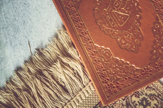 The Holy Quran on praying carpet. Flat lay view photo