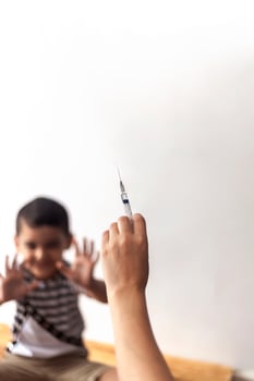 A doctor vaccinating young patient. Little boy scared of injection. Child's Immunization, Children's Vaccination, Health concept. photo