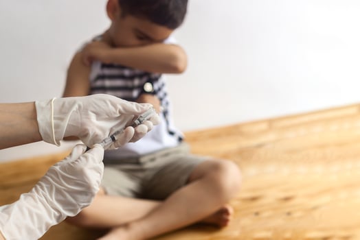 A doctor vaccinating young patient. Little boy scared of injection. Child's Immunization, Children's Vaccination, Health concept. photo
