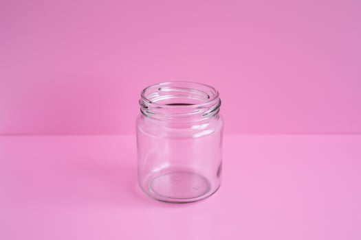 1 empty jar, no lid, with a pink scene, close up. photo