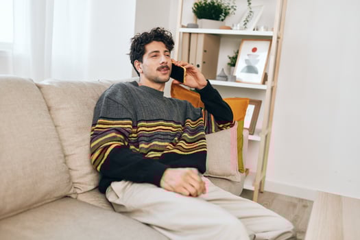 Man home smile couch cell phone lifestyle photo