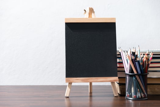 Back to school background with books on wooden table over chalkboard photo