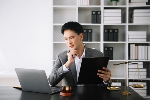 Attractive young lawyer in office Business man and lawyers discussing contract papers laptop and tablet with brass scale on  desk in office. photo