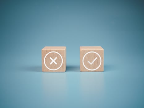 Wooden blocks with wrong and right symbols on light blue background. photo