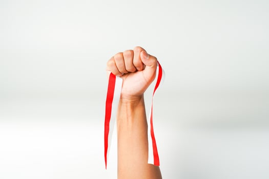 hand holding ribbon red white flag of Indonesia independence day August 17th  isolated on white background photo
