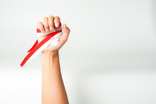hand holding ribbon, red and white flag of Indonesia independence day August 17th, i love indonesia, isolated on white background. photo