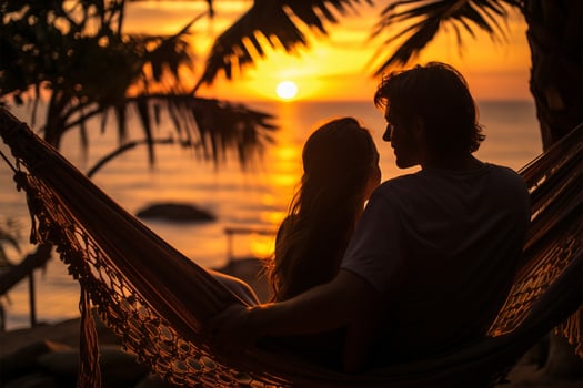Silhouette of young couple relaxing in hammock on tropical beach at sunset AI Generated photo