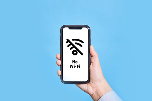 A person holds mobile phone with No-Wifi symbol on screen photo