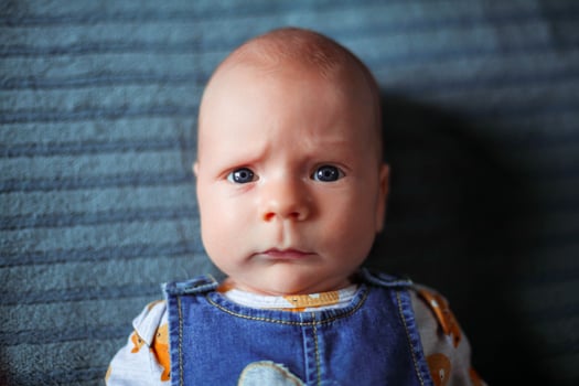 Funny baby 3 months old with a serious face photo