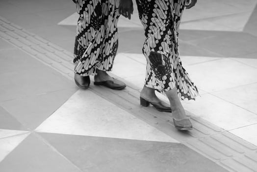 two women wearing patterned dresses walking on a tile floor photo