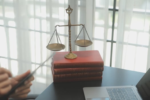 Business and lawyers discussing contract papers with brass scale on desk in office. Law, legal services, advice, justice and law concept picture with film grain effect photo