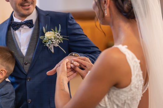 Bride puts a ring on a finger of a groom during a wedding ceremony, becoming husband and wife photo
