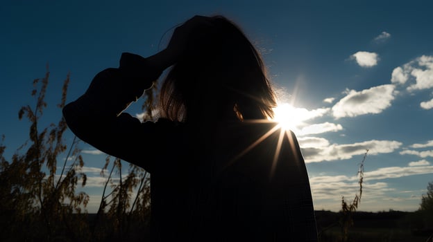 Silhouette of a tired and stressed woman against the sky, sun photo