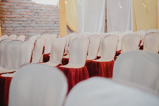 a row of chairs with white and red covers photo