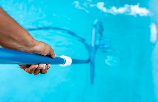 People cleaning swimming pool with suction hose. Close-up of man cleaning a swimming pool with a vacuum hose, Pool maintenance and cleaning with vacuum hose photo