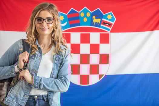 Croatian student in glasses stands in front of flag of Croatia photo