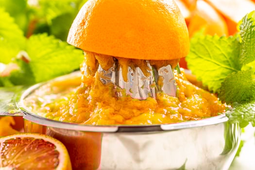 Staniless steel juicer full of orange pulp - close up photo