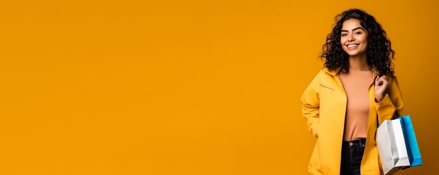 Woman with shopping bags yellow background with empty space photo