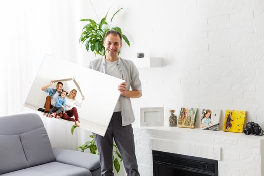 man holds photo canvas at home
