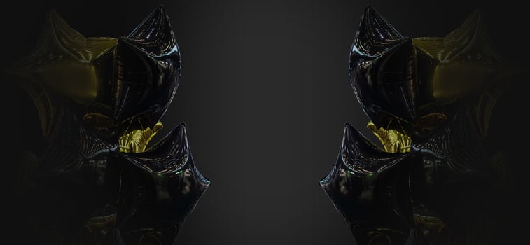A group of black and gold balloons on a black background with copy space photo