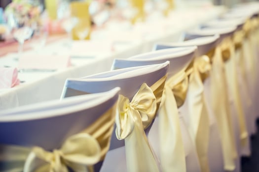 Wedding. Wedding chairs in row decorated with golden yellow color ribbon photo