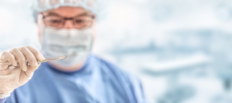 Doctor surgeon specialist with scalpel. In the background blurred the interior of the operating room photo