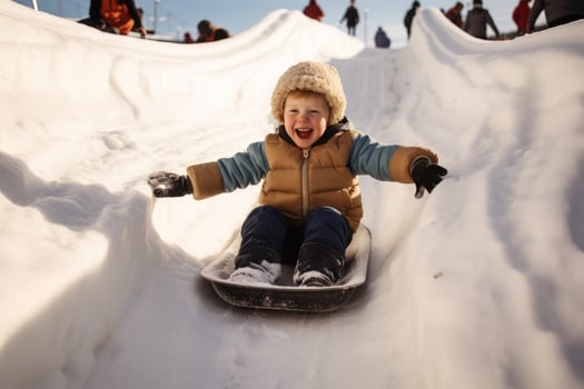 Boy riding snow slide outdoor. Generate Ai photo