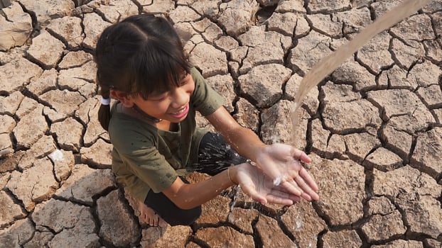 Asian girl rural sitting on dry ground. Water crisis, Concept hope and drought. photo