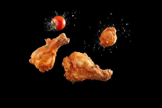 Flying elements of fried chicken with tomatoes and parsley, Generative AI photo