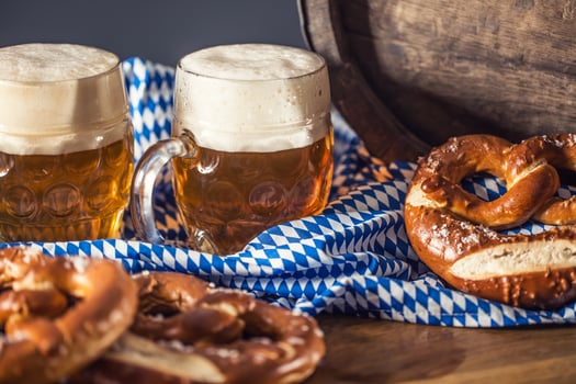 Oktoberfest two beer with pretzel wooden barrel and blue tablecloth photo