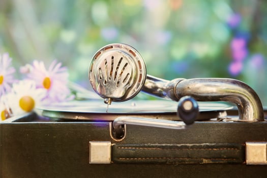 Vintage shot of a retro gramophone with a vinyl record and a romantic blurred bouquet of flowers. photo