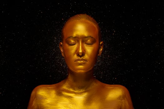 Model girl with festive golden glamorous shiny professional make-up. Beautiful golden metallic body, lips and skin. photo