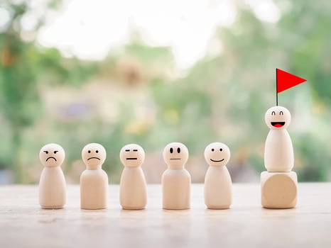 Wooden human figure on top of wooden block with red flag. Human Resource Development concept. Goals achievement and business success. photo