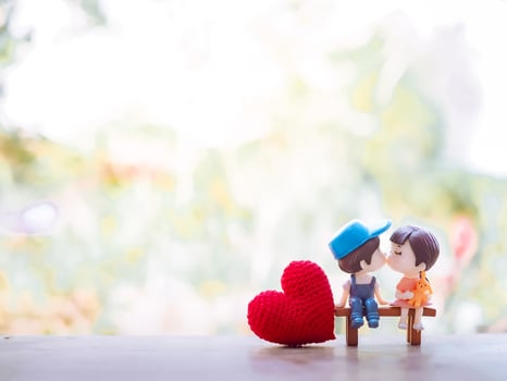 Close up of mini couple dolls in romantic kiss for Valentine's day concept photo