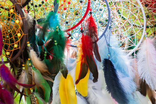 Multi-colored fluffy feathers are suspended on ropes. photo