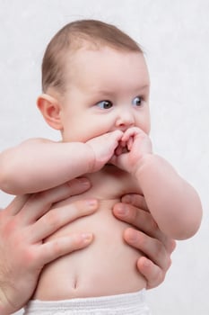 A six-month-old baby is in father's arms. photo