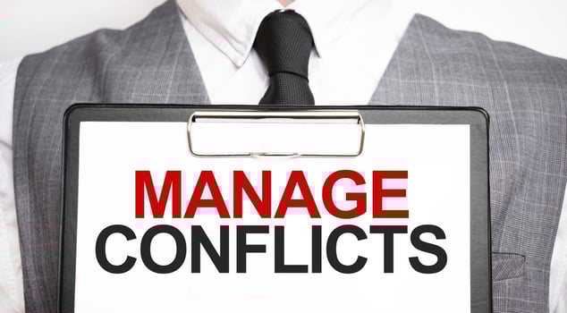 Businessman holding sheet of paper with a message MANAGE CONFLICTS photo