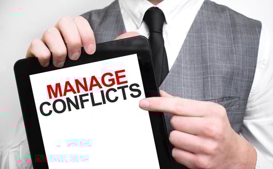 Businessman showing business concept on tablet standing in office MANAGE CONFLICTS photo