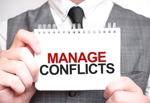Businessman with notebook with text MANAGE CONFLICTS photo