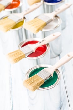 Close-up brushes lying on multicolored paint cans. photo