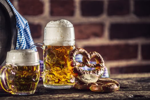 Oktoberfest large and small beer with pretzel wooden barrel and blue tablecloth photo