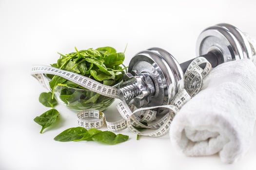 Spinach dumbbells and measure tape isolated on white background photo